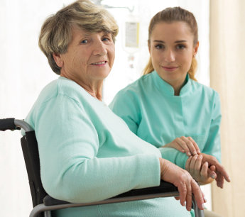 elderly woman in a wheelchair with her caregiver